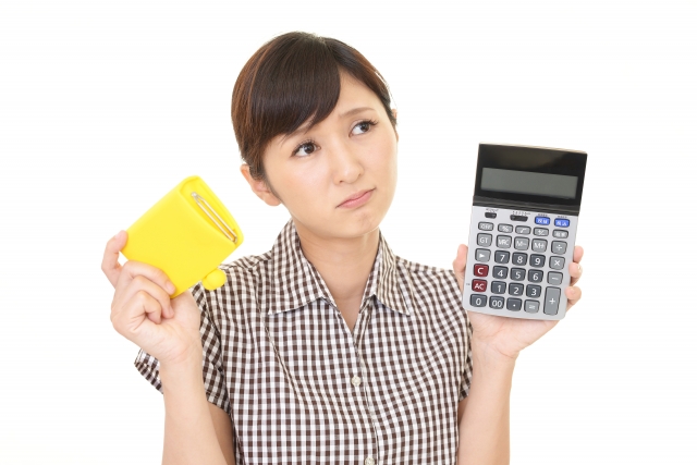 財布と電卓を持つ女性